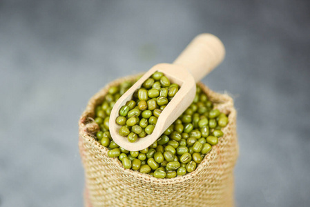 Green mung beans in the sack with wooden scoop  Mung bean seed 