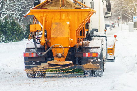 市政车在雪地里撒上沙子和盐