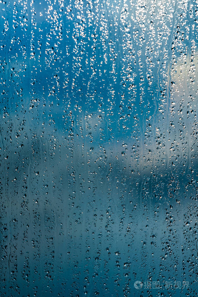雨点落在窗户的蓝色背景上