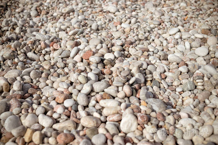 卵石背景小彩色鹅卵石背景，简洁，日光，石头。光滑园林用水磨卵石装饰。放松上海滩。抽象背景为圆形