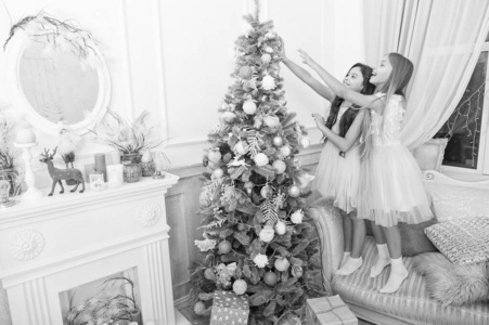 送圣诞礼物。快乐的小女孩姐妹们庆祝寒假。圣诞节时间。新年快乐。有圣诞礼物的小女孩。家庭假日。装饰圣诞树。看