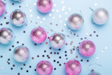 圣诞构图粉红色，银色的球和闪光在柔和的蓝色背景。圣诞节冬天新年概念