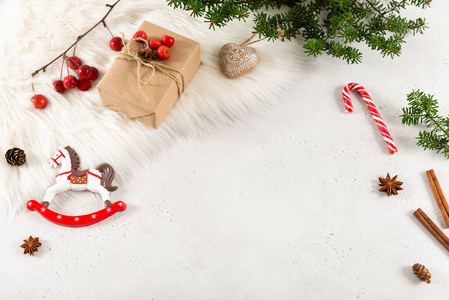 冬季背景由圣诞装饰品冷杉树枝和白色毛皮制成。新年快乐，圣诞快乐贺卡。复制空间，俯视图