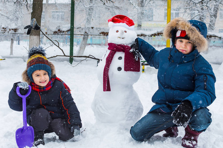 两个男孩正在堆雪人图片