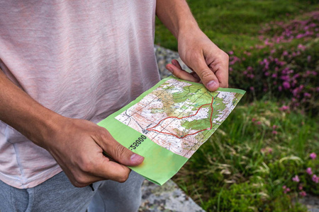 徒步旅行者持有夏季山脉地图