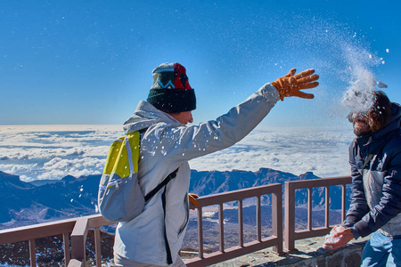 冬天，男孩和女孩在蓝色背景的山顶上玩雪