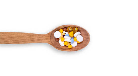 Medicine, pills and  in wood spoon on white background with 