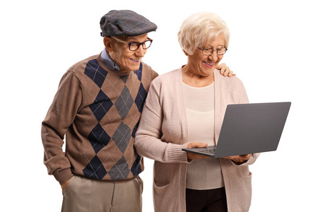 Happy senior couple smiling and looking at laptop computer 
