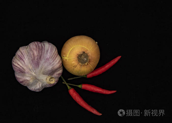 oniongarlicandpodsofhotpepperonablackbackground
