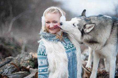 年轻女子抱着她的狗哈士奇
