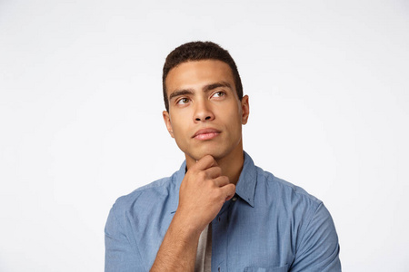 有趣的回忆特写体贴的巴西人,揉下巴抬头,思考想法,有一些计划,思考或