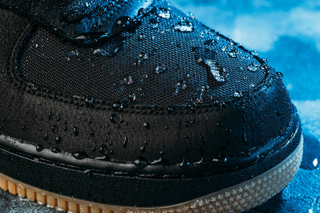 水珠落在鞋子表面的防水膜织物上。新的防水技术，适合积极的生活方式