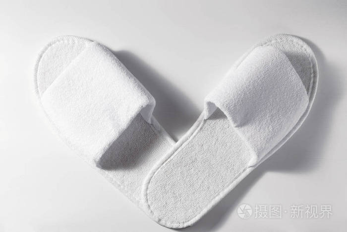 白色木质背景上白色拖鞋的俯视图一双空白的酒店鞋