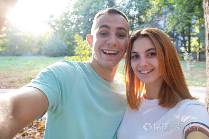 阳光明媚的阳光下幸福的小夫妻在户外自拍