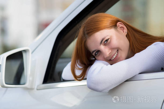 一个红头发的年轻女人在开车。