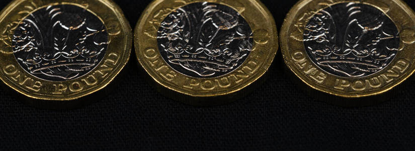 英国镑硬币的特写镜头，黑色背景，网页横幅