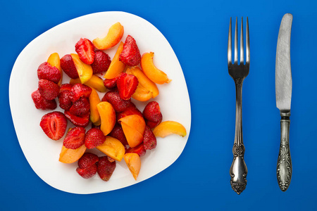 healthy food. Strawberries and apricots on a white plate. fresh 