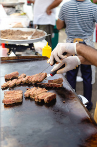 街头美食节上男人准备炸肉图片