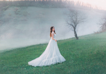 woman stands against the backdrop of a mountain landscape in a w