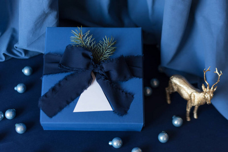 新年礼物，蓝色背景的蓝色盒子，带寒假装饰。圣诞背景与礼品盒。圣诞节庆祝礼物。