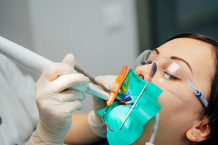 在牙医诊所接受牙科治疗的美女病人。女性造访口腔科。口腔护理。