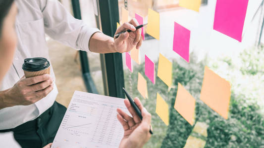 Business people meeting at  and use sticky notes on glass 