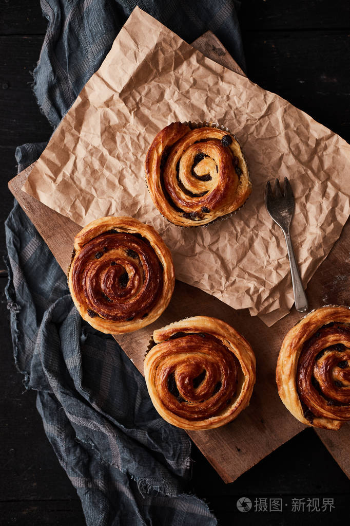 freshdanishpastrywithraisinsonwoodbackgroundtastysweet