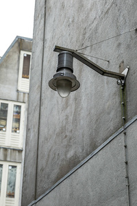 Street lamp on the gray wall of an old house. 