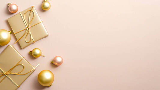 金色圣诞礼物和球在柔和的米色背景上，带有复制空间。魅力圣诞横幅设计与优雅时尚的装饰。新年贺卡模板，寒假横幅模型