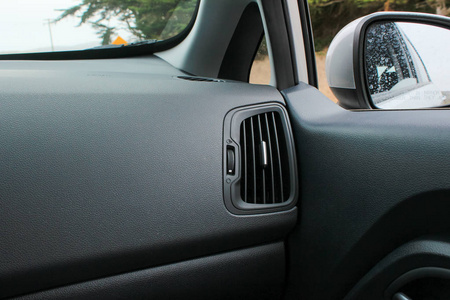 汽车内部有空调通风口和侧视镜.用于乘客侧气流的空调通风口.照片