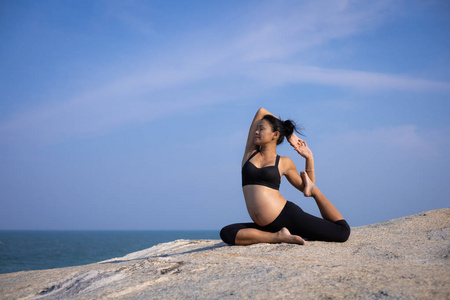  Asian pregnant woman yoga on the beach sunset summer time 