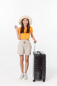 女游客。全身上下快乐的年轻女子拿着手提箱站着，做着激动人心的手势，孤立在白色背景上。