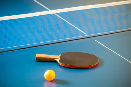 Empty blue table with a net and a yellow ball