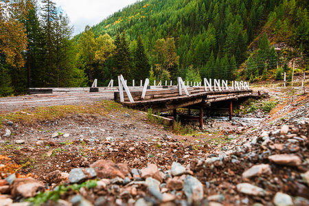 在多云的天气里，在森林里的河上有一座破旧的木桥。木桥被冲走了