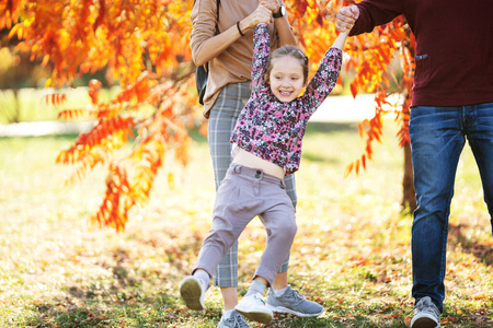 一家人带着女儿在秋天公园散步
