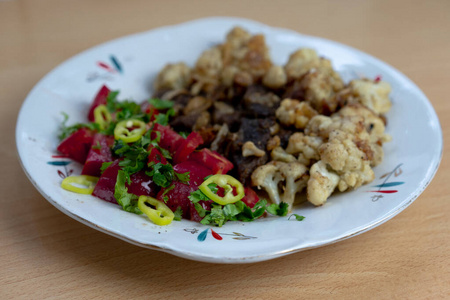 美味的午餐在盘子里。油炸肉片，花椰菜，辣酱