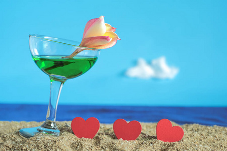 Summer day with cool cocktail on sea beach with red heart sign. 