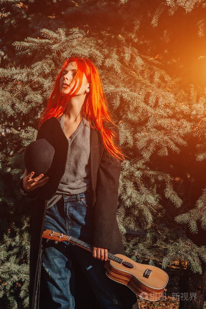 性感的红发女孩长发演奏四弦琴完美的女人肖像浓密浓密的秀发深蓝色的