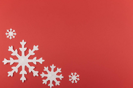 圣诞或新年构图，用红色背景上的雪花毡制成。冬季背景与装饰玩具，最小的概念。平躺。复制空间