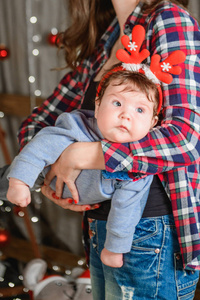 圣诞红喇叭。有趣的戴鹿角的婴儿。分别放在圣诞背景上。积极的新年