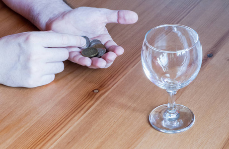 上花的钱桌上的酒杯硬币钱花在酒精上的特写手c照片