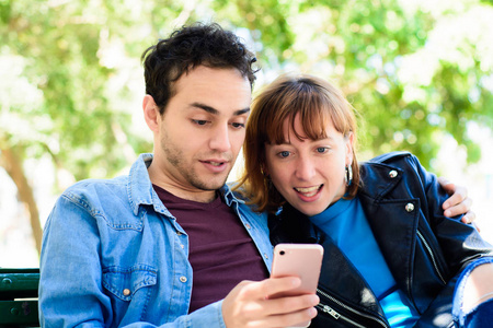 年轻夫妇在智能手机上使用应用程序