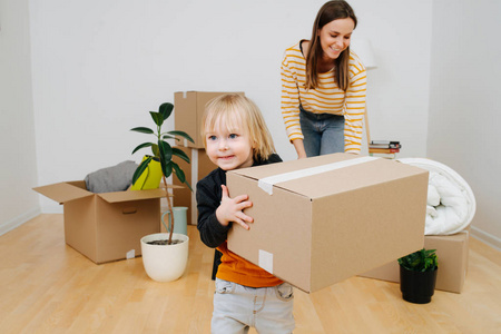 小儿子帮妈妈收拾行李,他们正从一间旧公寓搬出去.照片