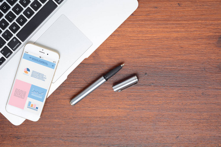 Office desk table and smartphone phone with graphic information 