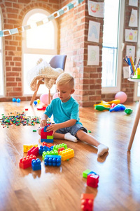 年轻的白人小孩在幼儿园玩玩具。就学前的