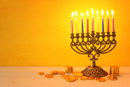 犹太节日光明节的宗教图像背景为烛台传统烛台和黄色背景上旋转的顶部