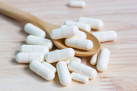 close up the capsules on wood table  