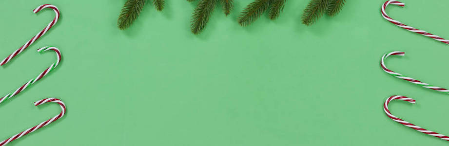 明亮的绿色背景与糖果棒和冷杉树枝