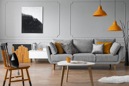 舒适的灰色沙发和枕头在优雅的客厅，斯堪的纳维亚设计