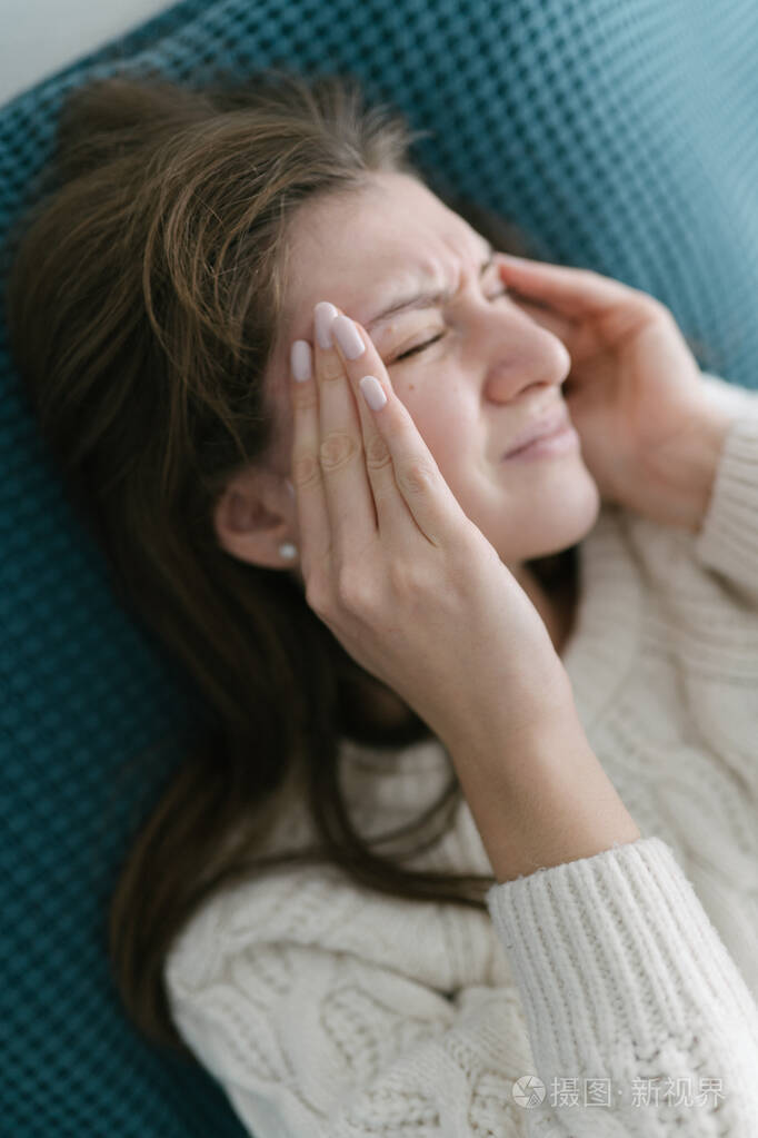 这个女人感到头痛揉着太阳穴痛苦地皱起了眉头季节性疾病白人女孩在